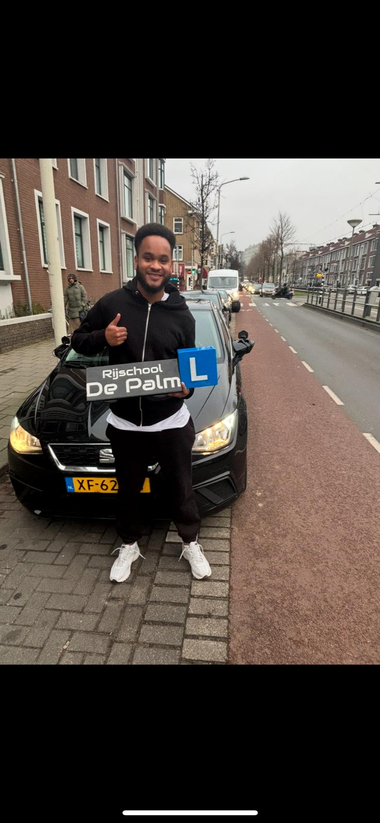 Leerling naast rijschoolauto